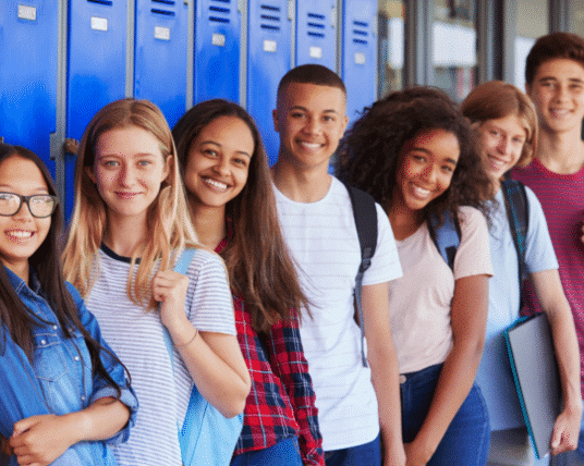 Group of students smiling by their lockers